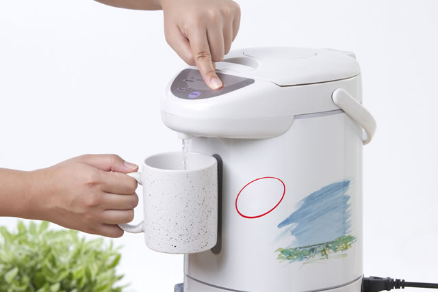 Pouring hot drinking from electric water boiler pot
