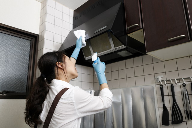 台所の換気扇を掃除している主婦