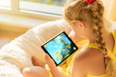 タブレットコンピュータでゲームをしている女の子